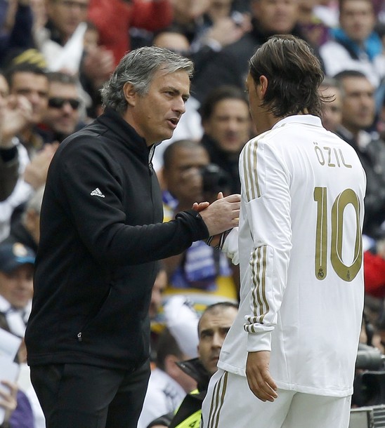 Real Madrid's coach Mourinho talks to Ozil during their Spanish First Division soccer match against Osasuna in Madrid