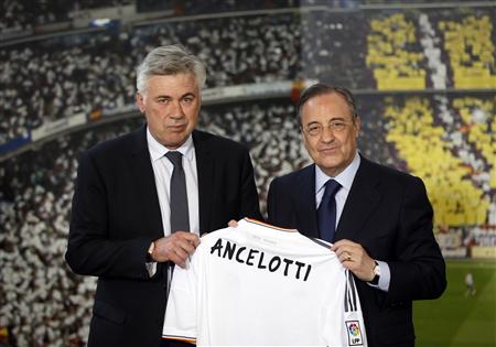 New Real Madrid coach Ancelotti holds a Real Madrid jersey as he poses with the club's President Perez during his official presentation at Santiago Bernabeu stadium in Madrid